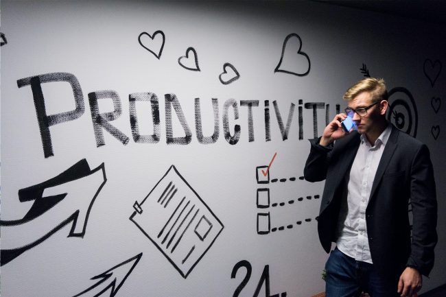 Productivity Man on mobile against productivity wall